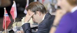 Mann blickt auf Laptop mit norwegischem Fähnchen auf dem Tisch