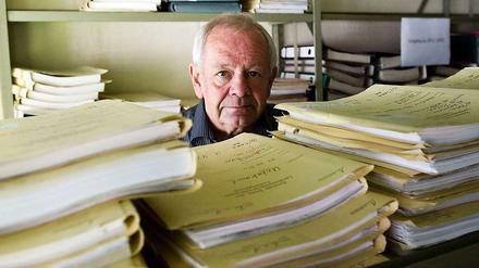 Kurt Schrimm, Leiter der Zentralen Stelle zur Aufklärung von NS-Verbrechen, zwischen Regalen mit Aktenbergen. 