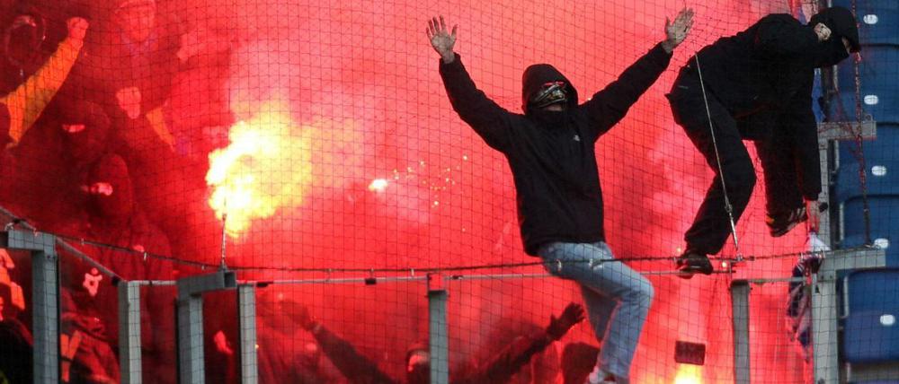 Skandalspiel: Die Dresdner Anhänger zünden bengalische Feuer im Gästeblock in Rostock.