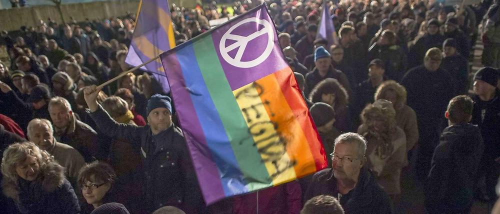 Optische Täuschung: Pegida will in Dresden für Frieden marschieren, dabei schüren diese Demonstranten nur Hass.