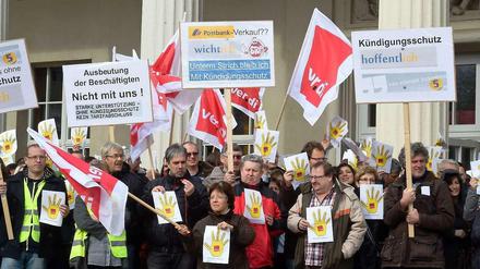 Beschäftigte der Postbank spielen auf ihren Protestplakaten mit dem aktuellen Slogan der Bank (Unterm Strich zähl' ich).