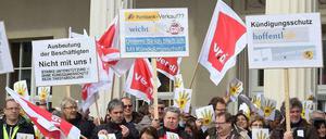 Beschäftigte der Postbank spielen auf ihren Protestplakaten mit dem aktuellen Slogan der Bank (Unterm Strich zähl' ich).