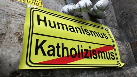 Am Rande einer Aktion kollektiver Kirchenaustritt klebte 2012 vor dem Standesamt in Mainz ein Schild mit der Aufschrift "Humanismus" und "Katholizismus (durchgestrichen).
