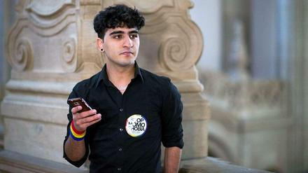 Gespannt wartet Nasser am Kriminalgericht in Moabit auf seinen Prozess. "Stop Homophobia!" - "Stoppt Schwulenfeindlichkeit!", fordert ein Sticker auf seinem Hemd.