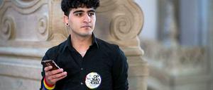 Gespannt wartet Nasser am Kriminalgericht in Moabit auf seinen Prozess. "Stop Homophobia!" - "Stoppt Schwulenfeindlichkeit!", fordert ein Sticker auf seinem Hemd.