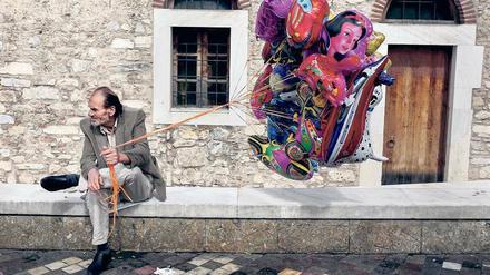 Jeder Cent zählt. Ein Mann in Athen möchte Luftballons an Urlauber verkaufen. 