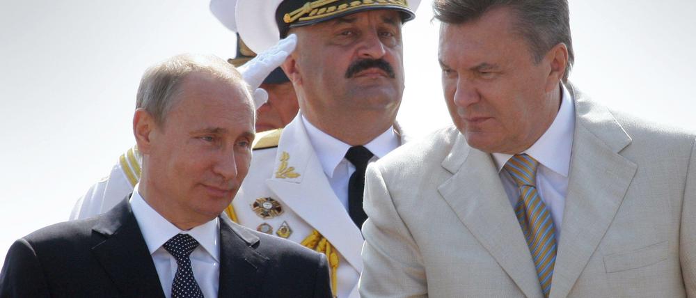 Wladimir Putin und der damaligen ukrainische Präsident Janukowitsch nehmen in Sewastopol an einer Parade zu Ehren der russischen Marine teil.