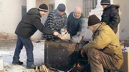 Am offenen Feuer kochen Bewohner der Stadt Mironowka.