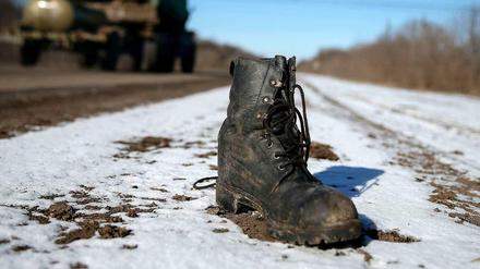 Ein Soldatenschuh steht am Rande einer Straße bei Debaltsewe.