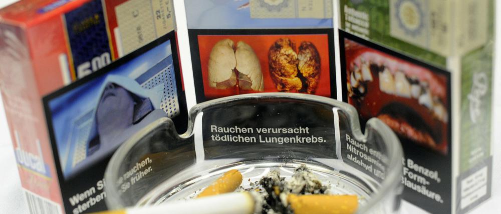 Zigarettenschachteln mit Aufdrücken von Folgeschäden des Zigarettenkonsums .