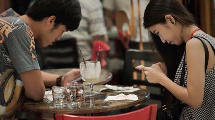 Menschen, die auf Smartphones starren: Ein Paar "kommuniziert"