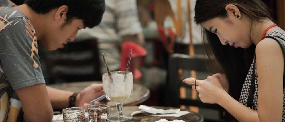 Menschen, die auf Smartphones starren: Ein Paar "kommuniziert"