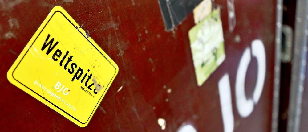 Der Aufkleber "Weltspitze" klebt auf einer Transportkiste für einen Kontrabass.