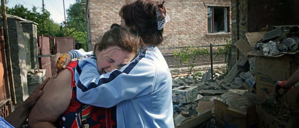 Die Kämpfe in der Ostukraine bringen der Bevölkerung viel Leid. Hier trauern Bürger in Slowjansk um ihr Haus, das bei Kämpfen zwischen der ukrainischen Armee und Separatisten zerstört wurde.
