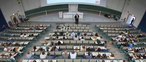 Ein Mann steht in einem Hörsaal vor Studierenden.