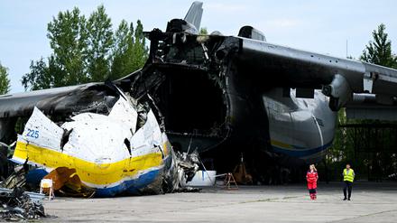 Arbeiter gehen in der Nähe des Wracks der Antonov AN-225 "Mriya" auf dem Flughafen Hostomel am Stadtrand von Kiew, Ukraine, spazieren.