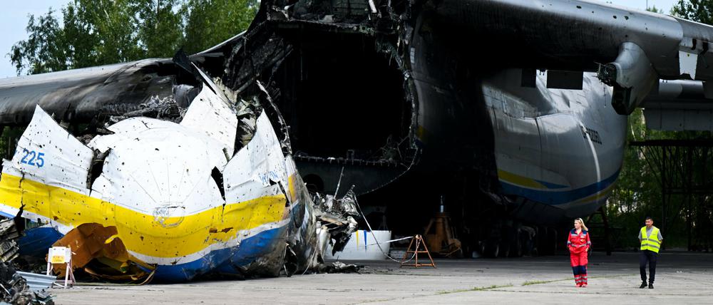 Arbeiter gehen in der Nähe des Wracks der Antonov AN-225 "Mriya" auf dem Flughafen Hostomel am Stadtrand von Kiew, Ukraine, spazieren. 