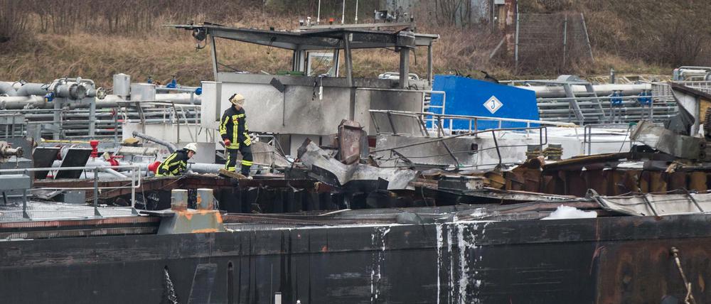 Feuerwehrmänner begutachten Teile des Schiffs.