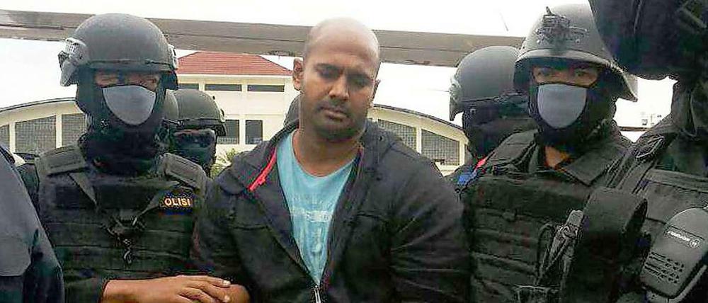 Polizisten in Indonesien bringen den zum Tode verurteilten Australier Myuran Sukumaran in den Sicherheitswagen, in welchem er Transportiert wird.