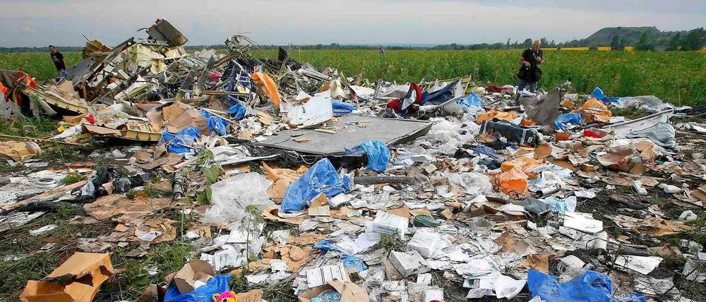 Trümmer und Blumen am Absturzort der MH17.