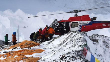 Rettungsmannschaften bergen mit einem Hubschrauber Verletzte am Mount Everest.