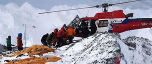 Rettungsmannschaften bergen mit einem Hubschrauber Verletzte am Mount Everest.