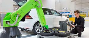 Ein junger Mann arbeitet an einer Montagestation eines Automobilherstellers.