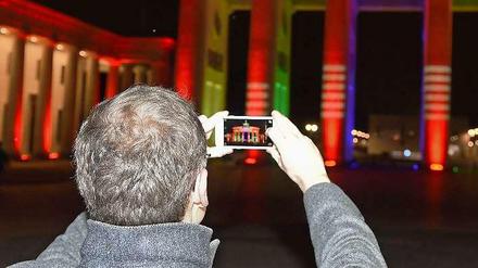 Der Regierende demonstriert: Um das für Olympia angestrahlte Brandenburger Tor zu fotografieren, ist ein Handy durchaus hilfreich - für die Olympia-Umfrage allerdings nicht. 