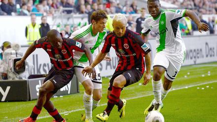 Lange eine zähe Angelegenheit: Frankfurts Djakpa und Schröck im Duell mit Wolfsburgs Träsch und Malanda (r.).