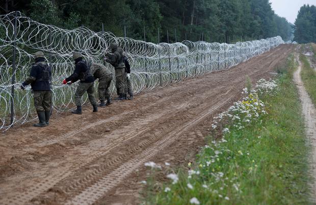 Polnische Soldaten errichten einen Zaun an der Grenze, um Flüchtlinge abzuhalten.