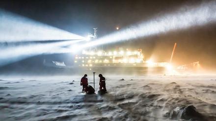 Forscher bauen eine Messstation vor der "Polarstern" auf. Die Mission will den Klimawandel in der Arktis erforschen.