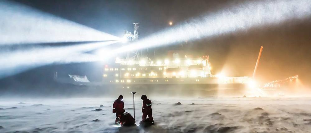 Forscher bauen eine Messstation vor der "Polarstern" auf. Die Mission will den Klimawandel in der Arktis erforschen.