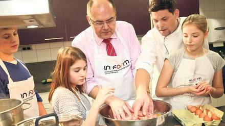 Alle mal mitmachen. Bundesminister Christian Schmidt und Fernsehkoch Tim Mälzer kochen mit Schülerinnen und Schülern der Schule Eins aus Pankow. 