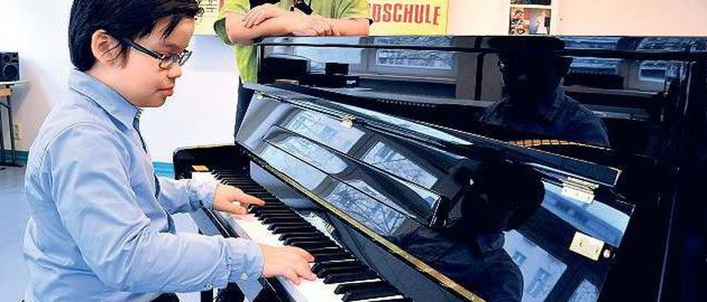 Der Junge am Klavier. Der neunjährige Odric spielt auf dem neuen Instrument in der Kurt-Tucholsky-Grundschule in Moabit. 