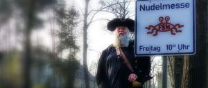 Schilda. Rüdiger Weida im Pastafari-Piratendress am noch sauberen Schild. Einige wurden beschmiert. Nun darf der Religionssatiriker eigene Masten nahe denen der Kirchen mit ihren Gottesdiensten anbringen.