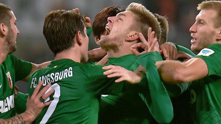 Augsburgs Alexander Esswein (Mi.) feiert sein Tor.