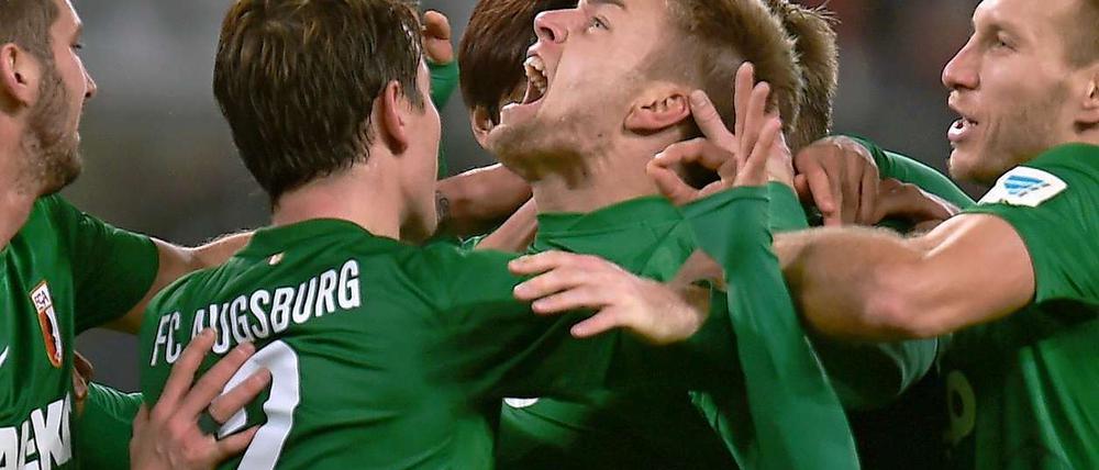 Augsburgs Alexander Esswein (Mi.) feiert sein Tor.
