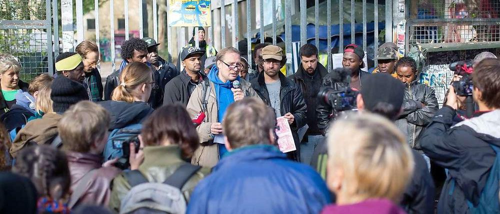 Stefan Fischer-Fels (mit Mikrofon) sichert den Flüchtlingen bei einer gemeinsamen Pressekonferenz vor der Kreuzberger Gerhart-Hauptmann-Schule Unterstützung zu.
