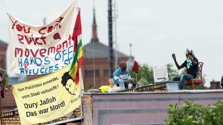 Sommer 2014: Flüchtlinge sind auf dem Dach der Gerhart-Hauptmann-Schule. Um eine Eskalation zu vermeiden, unterschrieb der Bezirk eine Vereinbarung mit den Flüchtlingen - die jetzt zum Problem wird.