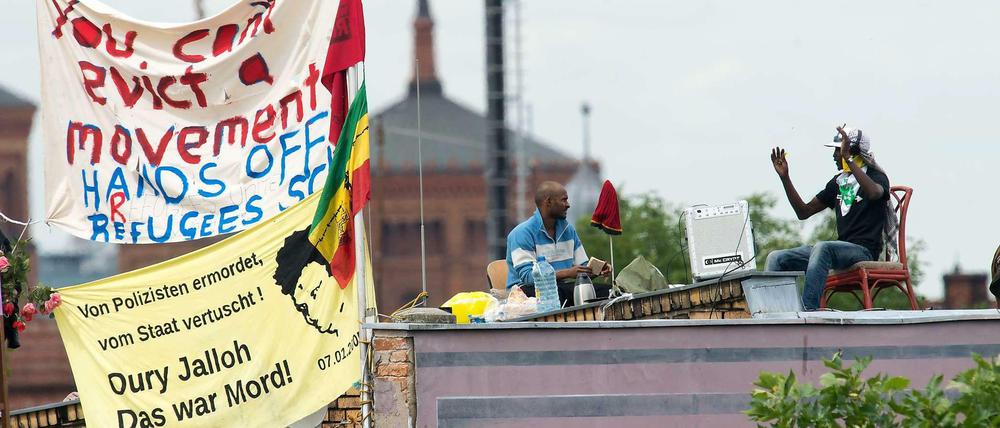Sommer 2014: Flüchtlinge sind auf dem Dach der Gerhart-Hauptmann-Schule. Um eine Eskalation zu vermeiden, unterschrieb der Bezirk eine Vereinbarung mit den Flüchtlingen - die jetzt zum Problem wird.