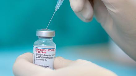 Eine Krankenschwester zieht den Impfstoff des Herstellers Moderna gegen das Coronavirus in einer gestellten Situation mit einer Spritze auf.
