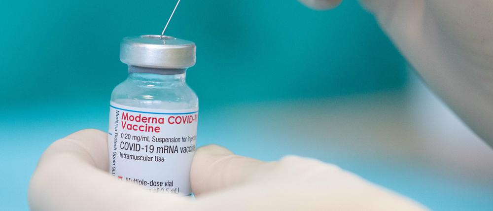Eine Krankenschwester zieht den Impfstoff des Herstellers Moderna gegen das Coronavirus in einer gestellten Situation mit einer Spritze auf.