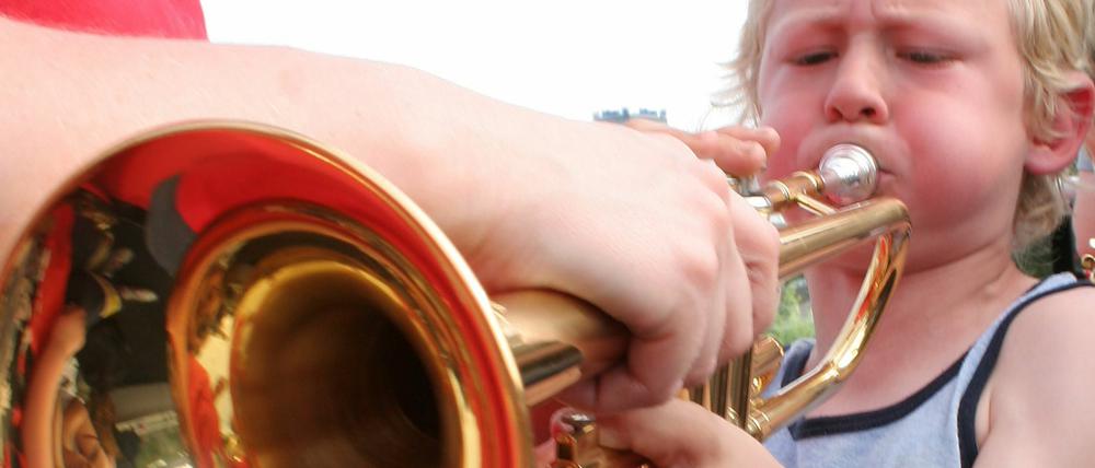 Junge bläst kräftig in eine Trompete. Promobild zur 12. Fete de la Musique in Berlin.