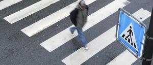 Ein Fußgänger geht über einen Zebrastreifen. (Symbolfoto) 