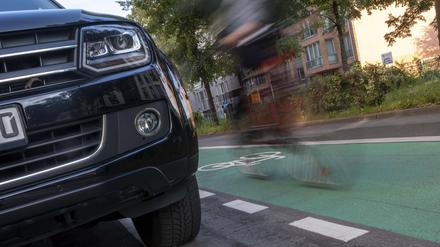 Front eines massiven SUV und Fahrradfahrer in Berlin.
