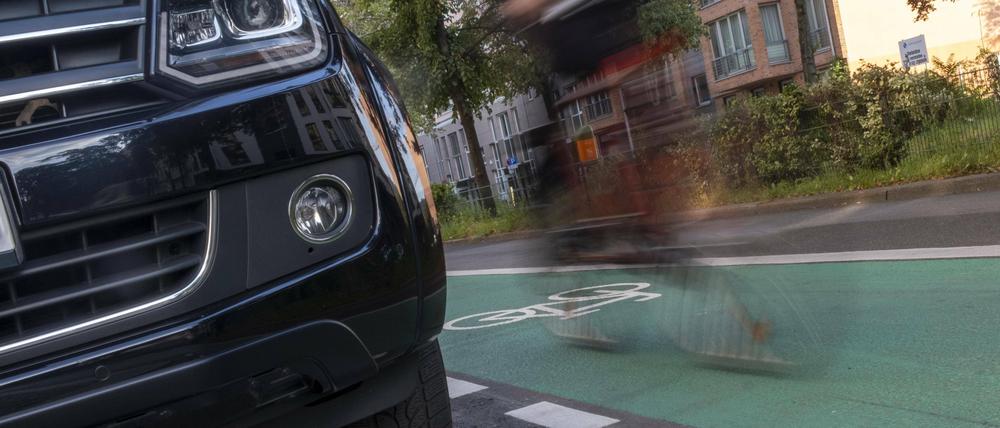 Front eines massiven SUV und Fahrradfahrer in Berlin.