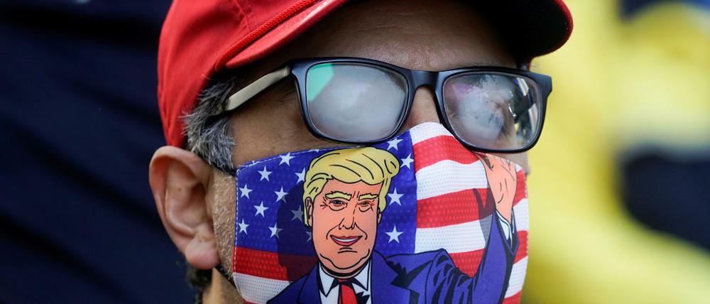 A supporter of U.S. president Donald Trump is pictured wearing a face mask and a ‘Make America Great Again’ cap as Trump supporters gather to demand a fair count of the votes of the 2020 U.S. presidential election, in Philadelphia, Pennsylvania, U.S., November 5, 2020. REUTERS/Eduardo Munoz     TPX IMAGES OF THE DAY