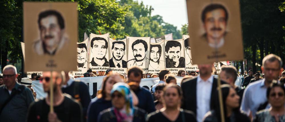 Demonstranten halten bei einer Kundgebung im Juli 2018 in München Schilder mit Porträt-Abbildungen der NSU-Opfer.