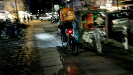 Ein Lieferando-Fahrer auf dem Gehweg.