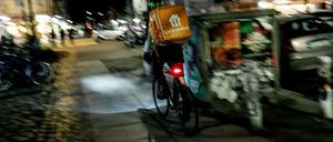 Ein Lieferando-Fahrer auf dem Gehweg.